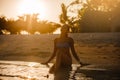 Pretty beautiful woman in swimwear bikini posing in blue sea water. Model enjoys her vacation in ocean at exotic Royalty Free Stock Photo