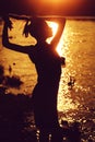 Female silhouette near water on sunset Royalty Free Stock Photo