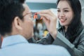a pretty shop clerk helps put new glasses on to a male customer Royalty Free Stock Photo