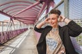 Pretty short hair girl listening to music on a bridge Royalty Free Stock Photo