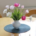 A pretty simple bunch of colourful tulips in a vase on the table Royalty Free Stock Photo