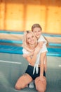 Pretty siters girls having fun indoor. Jumping on trampoline in children zone