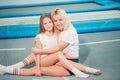 Pretty siters girls having fun indoor. Jumping on trampoline in children zone