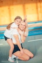 Pretty siters girls having fun indoor. Jumping on trampoline in children zone