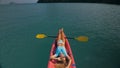 Pretty slim woman in elegant swimsuit lies in pink plastic kayak drifting on azure ocean at exotic resort upper view. Royalty Free Stock Photo