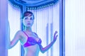 Pretty slim woman getting sun tan in solarium Royalty Free Stock Photo