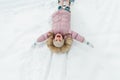 Pretty small girl enjoying winter outdoors. Little girl having fun with snow and sled in forest or park