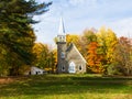 Pretty small protestant stone church surrounded by colourful fall foliage