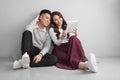 Pretty smiling asian couple in love together sitting on floor en Royalty Free Stock Photo