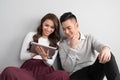 Pretty smiling asian couple in love together sitting on floor en Royalty Free Stock Photo