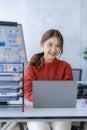 Pretty smiling asian female accountant working on laptop computer in modern office Royalty Free Stock Photo