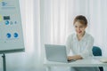 Pretty smiling asian female accountant working on laptop computer in modern office Royalty Free Stock Photo