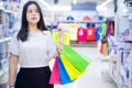 Pretty smiling Asian woman holding many shopping bags in the shopping mall. Shopping concept Royalty Free Stock Photo