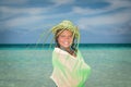 Pretty smiling beautiful little stylish girl on the beach against ocean and blue sky background Royalty Free Stock Photo