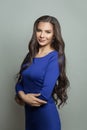 Pretty smiling brunette woman wearing blue dress on white background Royalty Free Stock Photo