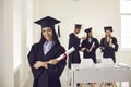 Pretty smiling caucasian girl student university graduate in mantle and bonet standing with diploma Royalty Free Stock Photo