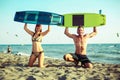 Pretty smiling couple kitesurfer enjoying summertime on sandy beach Royalty Free Stock Photo