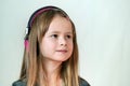 Pretty smiling cild girl listening to music in big pink earphones