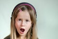 Pretty smiling cild girl listening to music in big pink earphones Royalty Free Stock Photo