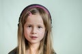 Pretty smiling cild girl listening to music in big pink earphones Royalty Free Stock Photo