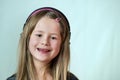 Pretty smiling cild girl listening to music in big pink earphones