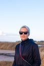 Pretty smiling confident woman in gray headband walking on sea background lifestyle real life travel. Millennial hipster