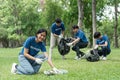 Pretty smiling female collecting forest garbage, looking at camera, volunteering