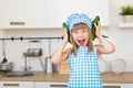 Pretty smiling girl in cook clothes funs with cucumbers Royalty Free Stock Photo