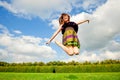 Pretty smiling girl is jumping on green meadow Royalty Free Stock Photo