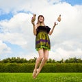 Pretty smiling girl is jumping on green meadow Royalty Free Stock Photo