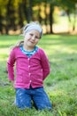 Pretty smiling girl portrait, standing on kneels on grass