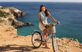 Pretty smiling girl riding a bicycle along the sea coast Royalty Free Stock Photo