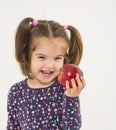 Pretty smiling girl teaches apple fruit