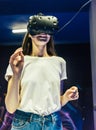 Pretty smiling girl touching her head wearing the virtual reality helmet Royalty Free Stock Photo