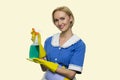 Pretty smiling housekeeper holding cleaning spray.