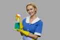 Pretty smiling housekeeper holding cleaning spray.