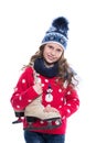 Pretty smiling little girl with curly hairstyle wearing knitted sweater, scarf and hat with skates isolated on white background. Royalty Free Stock Photo