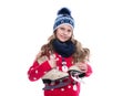 Pretty smiling little girl with curly hairstyle wearing knitted sweater, scarf and hat with skates isolated on white background. Royalty Free Stock Photo