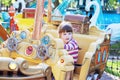 Pretty smiling little girl ride on carousel pirate ship
