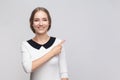Pretty smiling optimistic woman pointing finger aside at advertisement area copy space for promotion Royalty Free Stock Photo