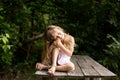 Pretty smiling pensive girl sitting on the old bridge Royalty Free Stock Photo