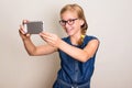 Pretty smiling teen girl in glasses making selfie photo on smart Royalty Free Stock Photo