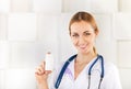 Pretty smiling woman doctor in uniform pointing a medicine bottle Royalty Free Stock Photo