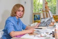 Pretty smiling woman drawing a picture with pencil. Front view on drawing girl with pencil in her hand. Royalty Free Stock Photo