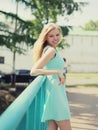 Pretty smiling woman in dress posing in the city