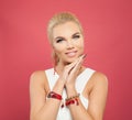 Pretty smiling woman in gold bracelets with coral and beads on colorful pink background Royalty Free Stock Photo