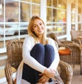 Pretty smiling woman sitting on armchair outdoors Royalty Free Stock Photo