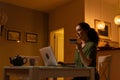 Pretty smiling young Caucasian woman is sitting at table, using laptop and holding bank credit card. Concept of payment Royalty Free Stock Photo