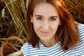 A pretty smiling young woman against the background of rye ears. Beautiful brunette on a wheat field at sunset. A lady in nature Royalty Free Stock Photo