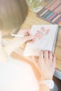 Pretty smiling young woman drawing a picture with poster paint, light toning